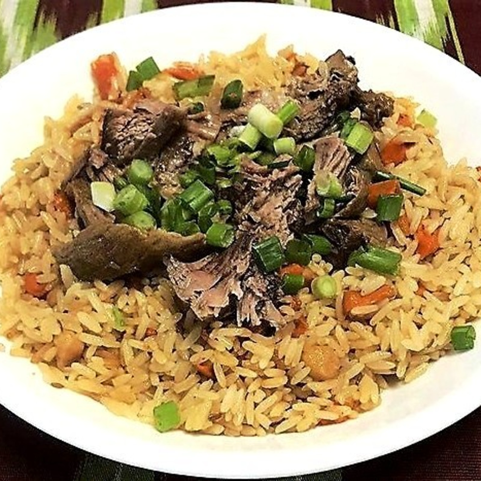 Plate of seasoned rice topped with grilled fish, mushrooms, chopped green onions, and diced vegetables.